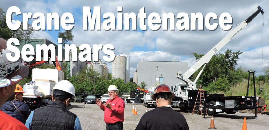 Instructor in red shirt talking to group while standing in front of stick boom crane